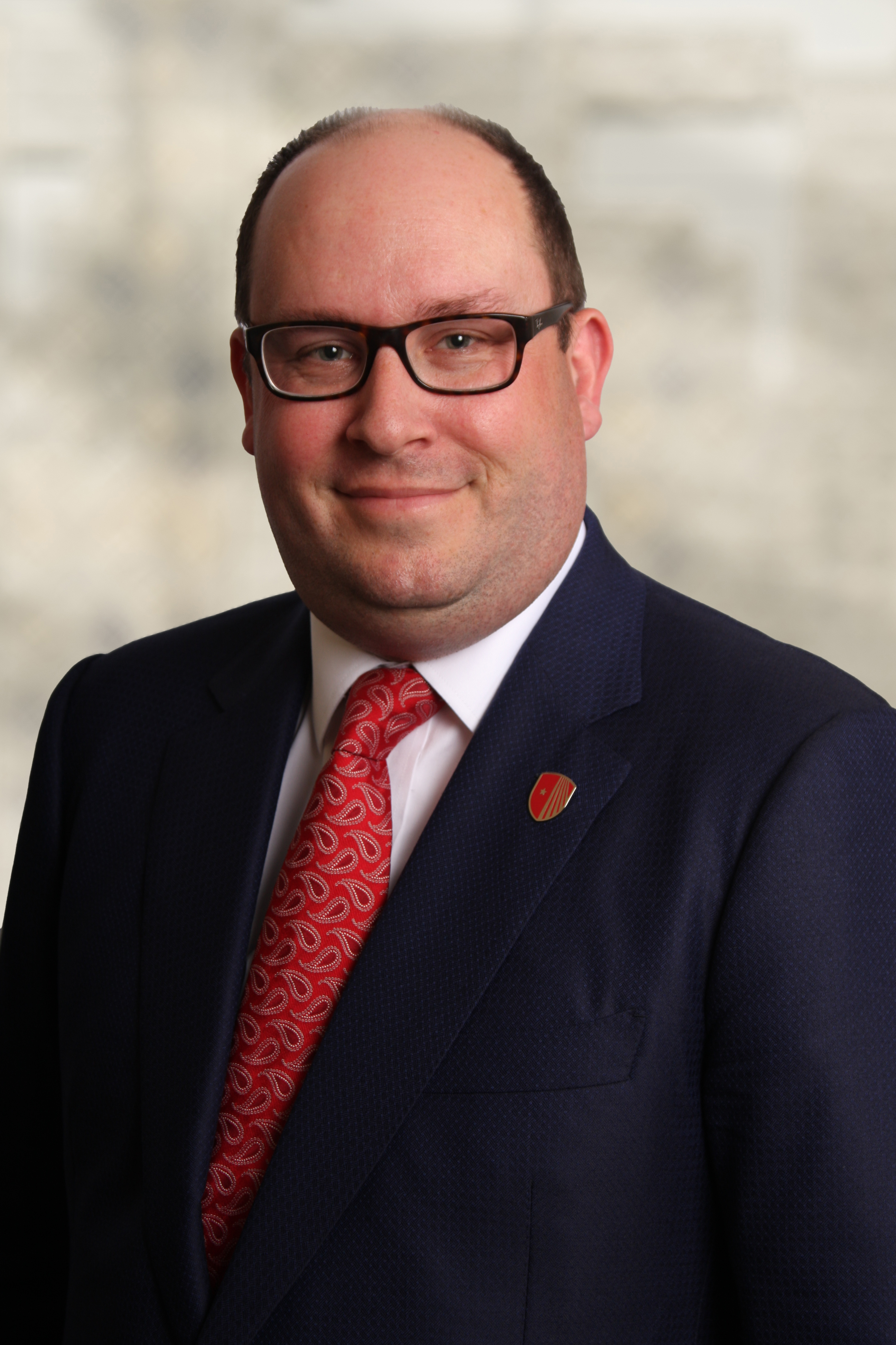 Michael D'Ambrosio, wearing a dark blue suit and red tie