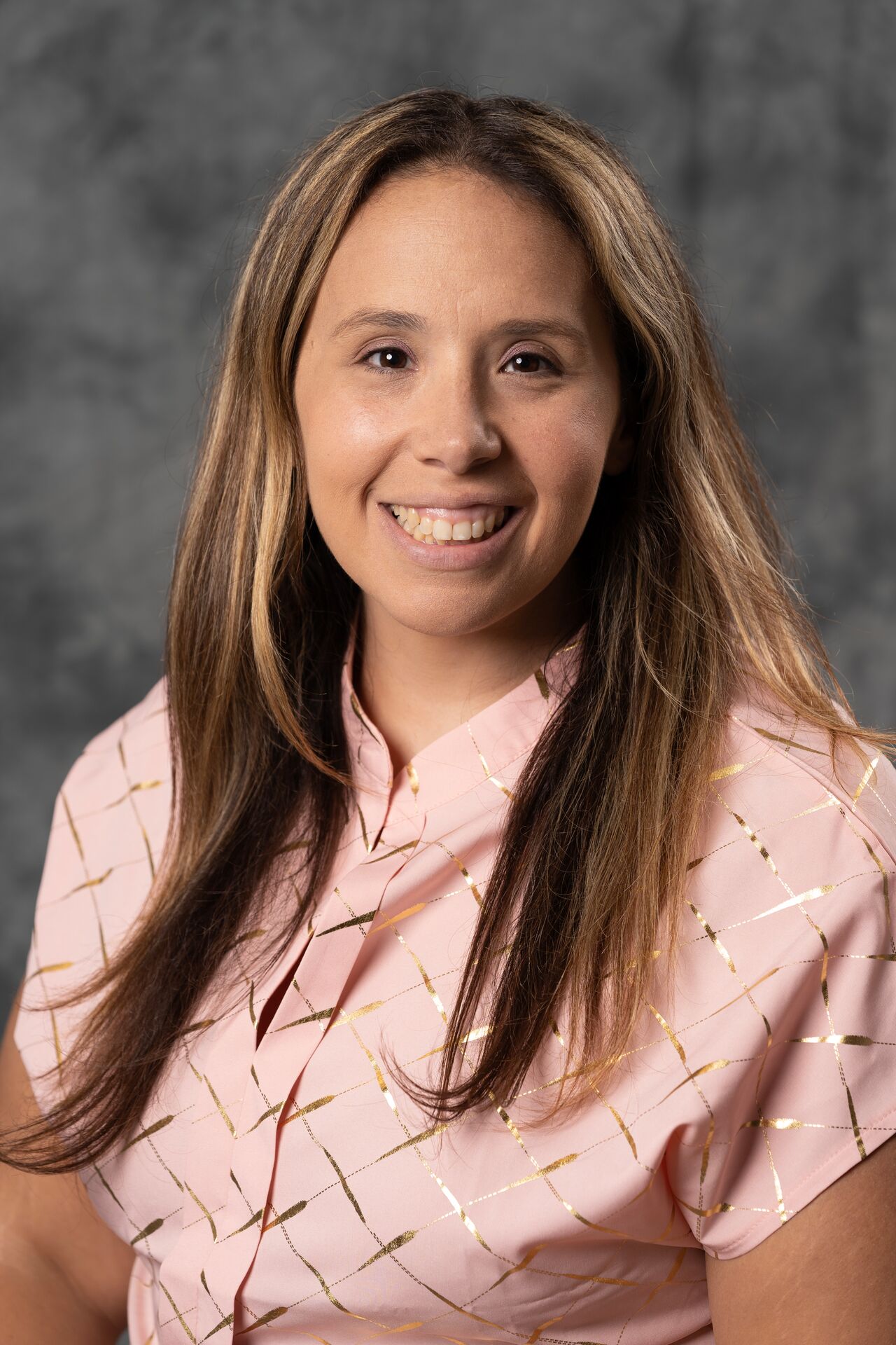 Danielle Papaspyrou, wearing a patterned pink collared shirt