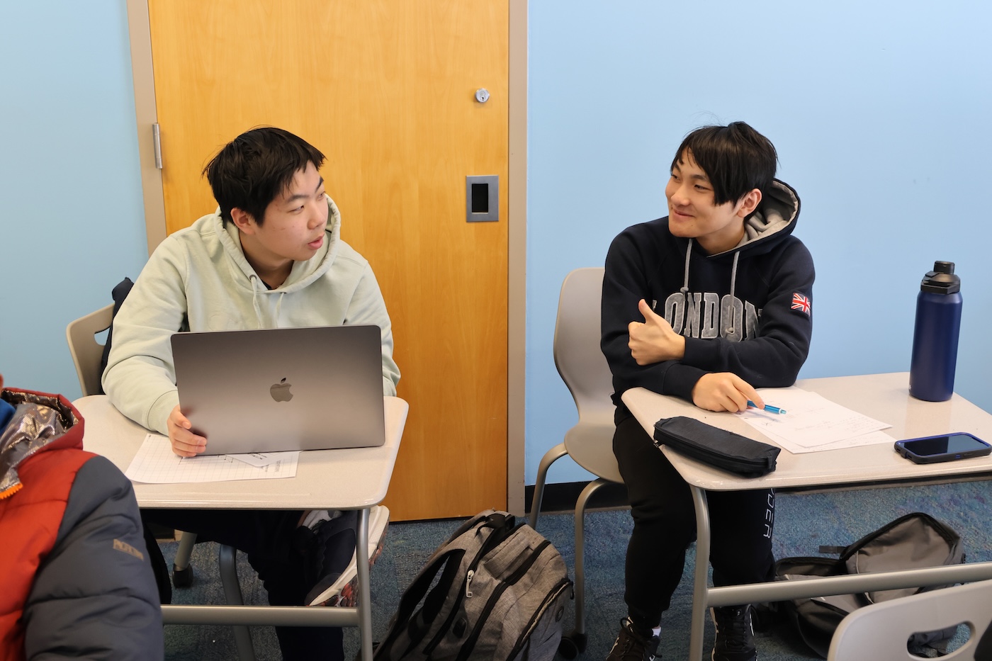 A research and tech student responding to a fellow student's question in the classroom