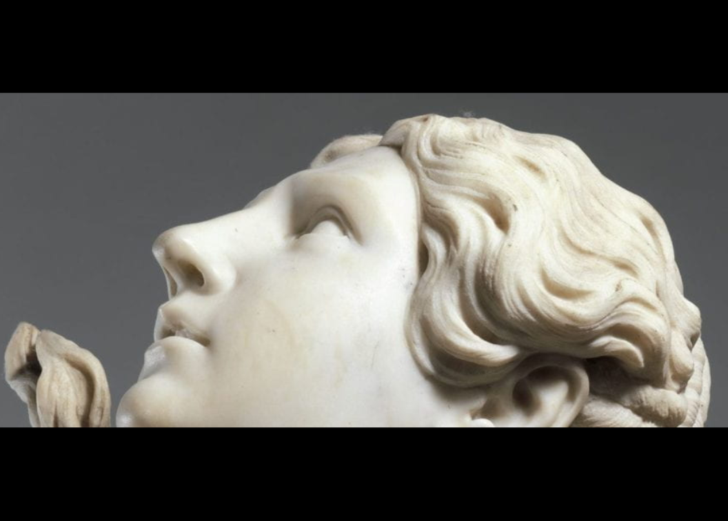 photo of the head of a sculpture on gray background